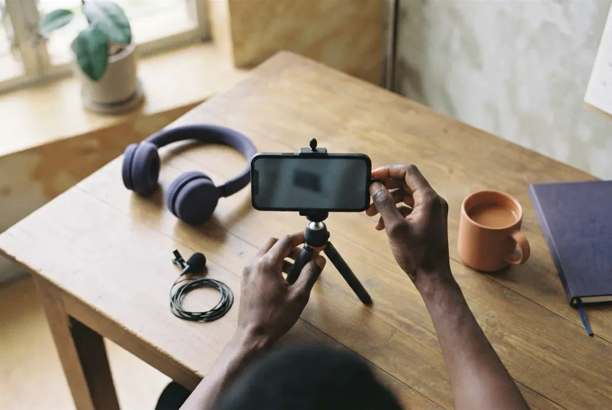 A phone on a tripod with a clip-on microphone, set up on a table